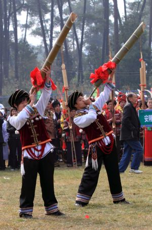 Two men blow the lusheng musical pipe to pray for good luck and bumper harvest during the Lusheng and Horse Fight Festival held in the Sports Park in Rongshui Miao Autonomous County, southwest China's Guangxi Zhuang Autonomous Region, Nov. 21, 2009.(Xinhua/Long Tao)