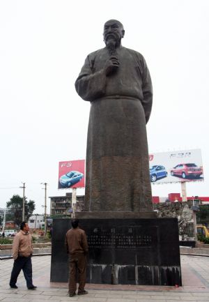 Two citizens look up at the bronze statue of Lin Zexu on the Lin Zexu Square which is under project of overall renovation, in the downtown of Fuzhou City, southeast China's Fujian Province, Nov. 21, 2009.(Xinhua/Zheng Shuai)