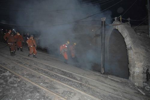 Rescue workers stand by the mine entrance as smoke billows out after a gas explosion at a coal mine in Hegang City, in northeast China's Heilongjiang Province, November 21, 2009.