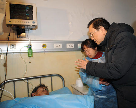 Chinese Vice Premier Zhang Dejiang (1st R) visits an injured miner at a hospital in Hegang City, northeast China's Heilongjiang Province, on Nov. 21, 2009. 