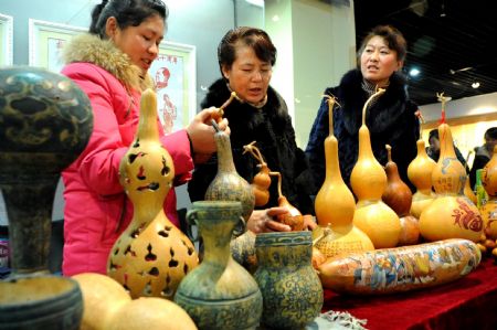 People enjoy the gourd craftwork at 2009 Lianyungang Culture Expo in Lianyungang, a city of east China's Jiangsu Province, Nov. 22, 2009. (Xinhua/Wang Chun)