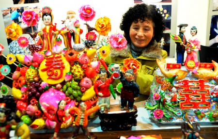 A folk craftswoman arranges dough figurines at 2009 Lianyungang Culture Expo in Lianyungang, a city of east China's Jiangsu Province, Nov. 22, 2009. (Xinhua/Wang Chun)