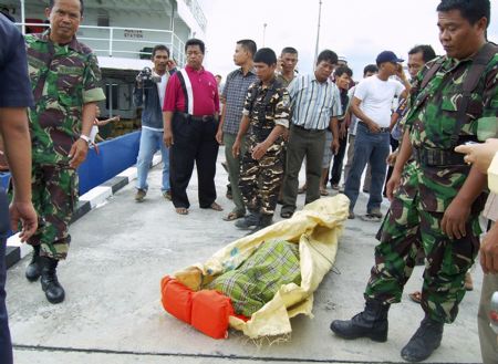 The recovered body of a victim of a sunken ferry arrive at port in Karimun island, Riau province November 22, 2009.