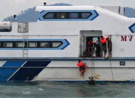 Rescuers recover body of a victim from a sunken ferry into a ship in Riau province November 22, 2009.