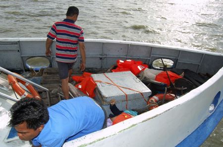 Rescuers check recovered bodies of victims of a sunken ferry, on a ship at port in Karimun island, Riau province November 22, 2009.