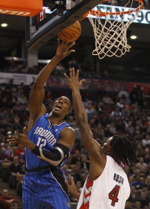 Orlando Magic's Dwight Howard (R) goes to the basket against Toronto Raptors Chris Bosh during the second half of their NBA basketball game in Toronto, November 22, 2009.(Xinhua/Reuters Photo)