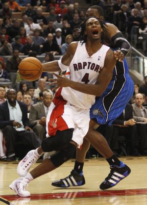 Toronto Raptors' Chris Bosh is guarded by Orlando Magic's Dwight Howard (R) during the first half of their NBA basketball game in Toronto, November 22, 2009.(Xinhua/Reuters Photo)
