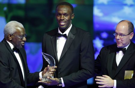 Usain Bolt of Jamaica receives his World Athlete of the Year Award from IAAF President Lamine Diack (L) and Prince Albert II of Monaco (R) during the IAAF World Athletics Gala in Monte Carlo November 22, 2009.(Xinhua/Reuters Photo)