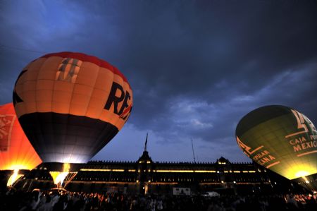 People look at hot air balloons during an exhibition at the Zocalo Square in Mexico City November 22, 2009.(Xinhua/AFP Photo)