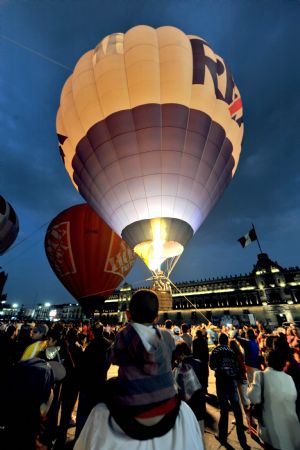 People look at hot air balloons during an exhibition at the Zocalo Square in Mexico City November 22, 2009.(Xinhua/AFP Photo)