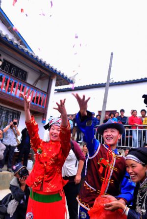 The "newlywed" distribute "happy-sweets" during a traditional wedding ceremony performance in a village of Maguan County, Zhuang-Miao Autonomous Prefecture of Wenshan, southwest China