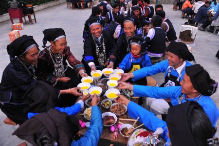 Woman of Zhuang ethnic group clad in their holiday bests make a toast during a traditional wedding ceremony performance in a village of Maguan County, Zhuang-Miao Autonomous Prefecture of Wenshan, southwest China's Yunnan Province, on Nov. 13, 2009. In slack farming season, villagers here prensent their traditional wedding custom of Zhuang ethnic group in Yunnan to tourists to promote the tourism here. (Xinhua/Chen Haining)