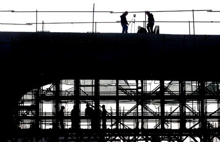  Workers are silhouetted while constructing the Zhengzhou Yellow River highway and railway dual-use bridge in central China's Henan Province, on Nov. 22, 2009. The bridge is expected to be completed in July 2010 and open to traffic in the end of October 2010. The bridge, connecting Zhengzhou and Xinxiang of Henan Province, serves as the longest (9,177 meters) huge-sized highway and railway dual-use bridge over the Yellow River, with the highest designed railway speed of 350 kilometers per hour. (Xinhua/Wang Song)