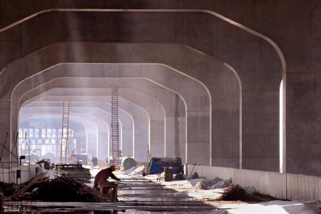 Workers construct the Zhengzhou Yellow River highway and railway dual-use bridge in central China's Henan Province, on Nov. 22, 2009. The bridge is expected to be completed in July 2010 and open to traffic in the end of October 2010. The bridge, connecting Zhengzhou and Xinxiang of Henan Province, serves as the longest (9,177 meters) huge-sized highway and railway dual-use bridge over the Yellow River, with the highest designed railway speed of 350 kilometers per hour. (Xinhua/Wang Song)