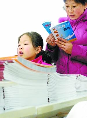 A little girl is choosing exercise books with her mother.