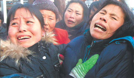 Relatives of miners killed in Saturday's underground explosion in Heilongjiang province are overcome with grief after gathering at the entrance to the Xinxing Coal Mine in Hegang yesterday. [Reuters]