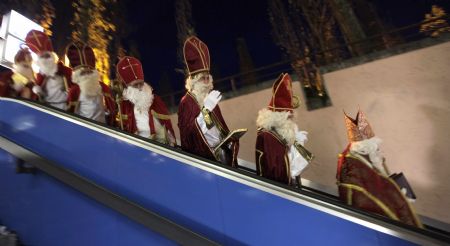 Men dressed as Santa Claus use an escalator after a meeting of the rent-a-Santa Claus service organised by the "jobcafe.de" at Munich