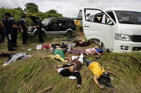 Dead bodies lie on the ground near their vehicles at the crime scene of a massacre of a political clan that included several journalists in the outskirts of Ampatuan, Maguindanao in southern Philippines Nov. 24, 2009. [Xinhua/Reuters Photo]