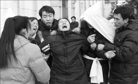 Relatives of miners killed in Saturday's blast in Hegang, Heilongjiang province, mourn at a funeral in the city yesterday.