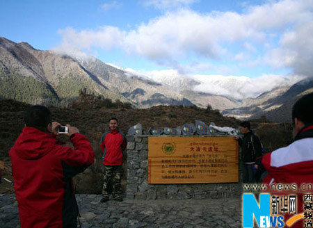 Tourists take pictures at the scenic spot of the Yarlung Zangbo Grand Canyon, Nyingchi Prefecture, southeastern Tibet, on November 21, 2009.(Xinhua Photo)
