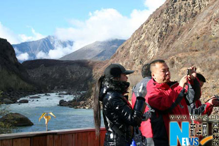  Tourists take pictures at the scenic spot of the Yarlung Zangbo Grand Canyon, Nyingchi Prefecture, southeastern Tibet, on November 21, 2009. (Xinhua Photo)