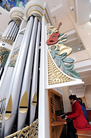 Junior students play a huge pipe organ at the Shenyang Conservatory of Music in northeast China's Liaoning Province on Nov. 24, 2009. The newly-installed organ with a height of nine metres and weight of seven tons are made of about 2,000 pipes, among which are 60 wood pipes and over 1,900 metal pipes.