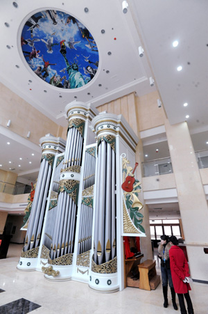 Junior students admire a huge pipe organ at the Shenyang Conservatory of Music in northeast China's Liaoning Province on Nov. 24, 2009. The newly-installed organ with a height of nine metres and weight of seven tons are made of about 2,000 pipes, among which are 60 wood pipes and over 1,900 metal pipes.