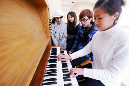 Junior students play a huge pipe organ at the Shenyang Conservatory of Music in northeast China's Liaoning Province on Nov. 24, 2009. The newly-installed organ with a height of nine metres and weight of seven tons are made of about 2,000 pipes, among which are 60 wood pipes and over 1,900 metal pipes.