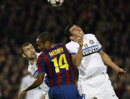 Barcelona's Thierry Henry (C) heads the ball between Inter Milan's Lucio (R) and Walter Samuel during their Champions League soccer match at Nou Camp stadium in Barcelona November 24, 2009.