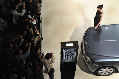 A model stands next to a Rolls-Royce car during the 7th Guangzhou International Auto Show opened in Guangzhou, south China's Guangdong Province, Nov. 24, 2009. Some 720 automibles from over 60 auto makers are on show.