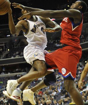 Samuel Dalembert(R) of Philadelphia 76ers blocks Gilbert Arenas of Washington Wizards during their NBA game in Washington D.C.,the United States, Nov. 24, 2009. Wizards won 108-107. (Xinhua/Zhang Yan) 