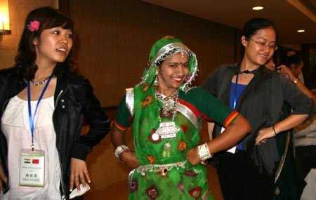 Chinese youths learn Indian traditional dance from an Indian youth (C) during a party in Ahmadabad, India, Nov. 24, 2009. A 100-member youth delegation led by He Junke, secretary of the Secretariat of the Central Committee of the Communist Youth League of China, visit India from Nov. 9 to 28. (Xinhua/Mao Xiaoxiao)