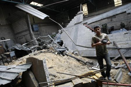 A Palestinian inspects a factory's workshop destroyed in an Israeli air strike near the border between Egypt and the southern Gaza Strip November 24, 2009. Three Palestinians were wounded early on Tuesday as Israel carried out three air strikes on Hamas-run Gaza in response to rocket fire from the enclave, witnesses, medics and the army said.(Xinhua/AFP Photo)