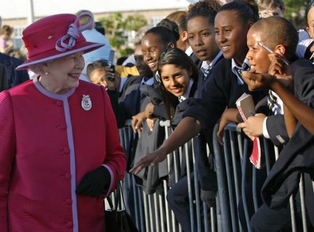 Britain's Queen Elizabeth (L) is greeted by school children after her arrival at King's Square, St. George's in Bermuda November 24, 2009. The queen's three-day visit commemorates the 400th anniversary of the island.