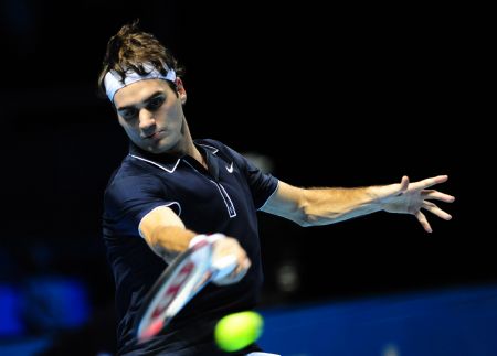 Roger Federer of Switerland returns a hit to Andy Murray of Britain during a Group A match at ATP World Tour Finals in London, capital of Britain, Nov. 24, 2009. Federer won 2-1. (Xinhua/Zeng Yi)