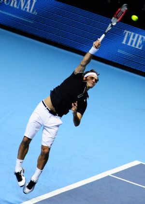 Roger Federer of Switerland returns a hit to Andy Murray of Britain during a Group A match at ATP World Tour Finals in London, capital of Britain, Nov. 24, 2009. Federer won 2-1. (Xinhua/Zeng Yi)