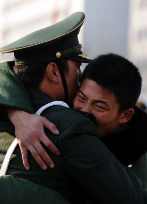 Armed policemen who have retired hug each other at a railway station in Taiyuan, capital of north China's Shanxi Province, Nov. 25, 2009. More than 500 armed policemen retired here on Wednesday. (Xinhua/Yan Yan)