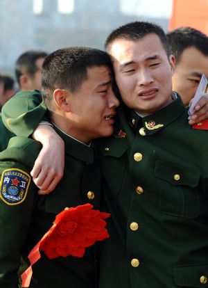 Armed policemen who have retired hug each other at a railway station in Taiyuan, capital of north China's Shanxi Province, Nov. 25, 2009. (Xinhua/Yan Yan)