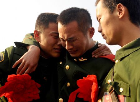 Armed policemen who have retired hug each other at a railway station in Taiyuan, capital of north China's Shanxi Province, Nov. 25, 2009. (Xinhua/Yan Yan)