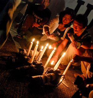 Journalists hold a candlelight indignation rally after a stunning massacre of journalists, civilians and relatives of politicians happened in Maguindanao of the southern Philippines, in Manila, Nov. 24, 2009. The death toll in the stunning massacre of journalists, civilians and relatives of politicians three days ago in the volatile southern Philippines stood at more than 50, police said on Wednesday. (Xinhua/Jonas Sulit)