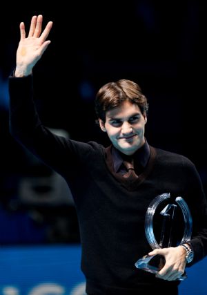 Roger Federer of Switzerland poses with the No.1 trophy at the ATP World Tour Finals tennis tournament in London, Nov. 25, 2009. He clinched the 2009 ATP World Tour year-end No.1 for the fifth time after He defeated Andy Murray of Britain at the ATP World Tour Finals Tuesday night. (Xinhua/Tang Shi)