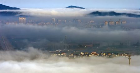 Photo taken at 8:30 am on Nov. 25, 2009 shows a fairyland view of an array of farmers' household dwellings and the residences of county's seat residents afloat over the advection fog, in a rare spectacular scene that betides in coastal Xiangshan County, east China's Zhejiang Province. (Xinhua/He Yousong)