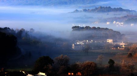 Photo taken on Nov. 25, 2009 shows a fairyland view of terraced folk dwellings hazed in the expansive dense fog, at the mountainside of Yellow Mountain, in Yixian, east China's Anhui Province. (Xinhua/Shi Guangde)
