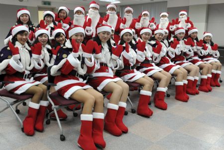 Participants dressed in a Santa Claus outfits pose for photographs during a promotional event for the Christmas holiday season at the Everland amusement park in Yongin, about 50 km (31 miles) south of Seoul, November 25, 2009.(Xinhua/Reuters Photo)