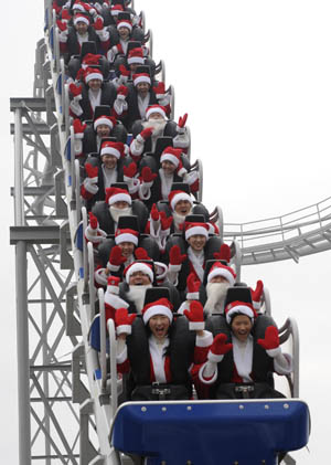 Participants dressed in Santa Claus outfits ride a roller coaster during a promotional event for the Christmas holiday season at the Everland amusement park in Yongin, about 50 km (31 miles) south of Seoul, November 25, 2009.(Xinhua/Reuters Photo)