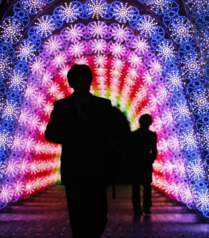 Caption People walk under light emitting diodes (LED) used as Christmas decorations in Tokyo November 24, 2009.(Xinhua/Reuters Photo)