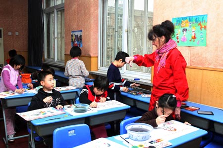 Anna Mare Holm, a Danish female acts artist, gives advice to be imaginative to a group of pupils who practise with their children's paintings, during an activity on the Fairy Tale World of the Children Heart, Genuine Nature and Fun, at the Hepingli Elementary School No.1, of Beijing, Nov. 25, 2009. (Xinhua/Zhou Liang)