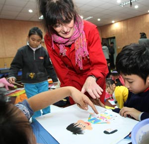 Anna Mare Holm, a Danish female acts artist, gives advice on children's painting, during an activity on the Fairy Tale World of the Children Heart, Genuine Nature and Fun, at the Hepingli Elementary School No.1, of Beijing, Nov. 25, 2009. (Xinhua/Zhou Liang)