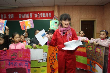 Anna Mare Holm, a Danish female acts artist, talks to a group of pupils who practise with their children's paintings, during an activity on the Fairy Tale World of the Children Heart, Genuine Nature and Fun, at the Hepingli Elementary School No.1, of Beijing, Nov. 25, 2009. (Xinhua/Zhou Liang)