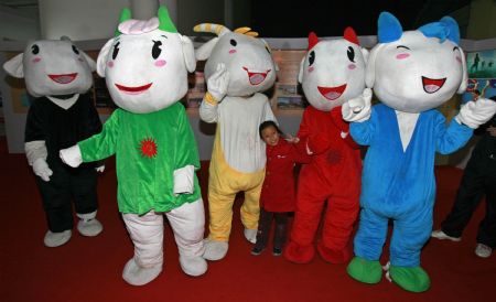 A little girl poses for photo-taking with the mascots Leyangyang, namely happy goat, on the high-profile publicity of the 2010 Asian Games in Guangzhou, which is on schedule from November 12-27 next year, during the activity of Round Tour of Asian Games in China, at Wuhan, central China